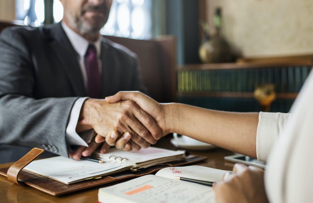 Business man and woman shaking hands at civil litigation meeting
